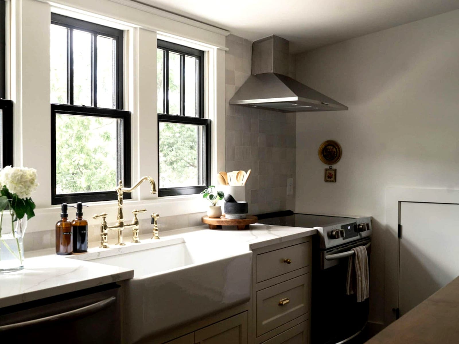 A Boost-managed Nashville kitchen — a brass bridge tap over a farmhouse sink, black-framed windows