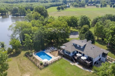 Enjoy a dreamy getaway at this Luxurious Lakeside Estate! Across 6 private acres this unit offers endless options for you to relax, unwind, and have some fun. The home features a pool, hot tub, sauna, and plenty of space for your group to enjoy a home away from home!
This property is a 25 minute drive to the Nations neighborhood in Nashville and a 35 minute drive to Downtown Nashville.